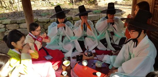 전국 첫 ‘프래밀리 소셜다이닝’ 행사에 참가한 중학생들이 지난 22일 전남 강진군 성전면 백운동 별서정원에서 열린 ‘조선의 가든 티파티’에서 한복을 차려입고 차를 마시고 있다.