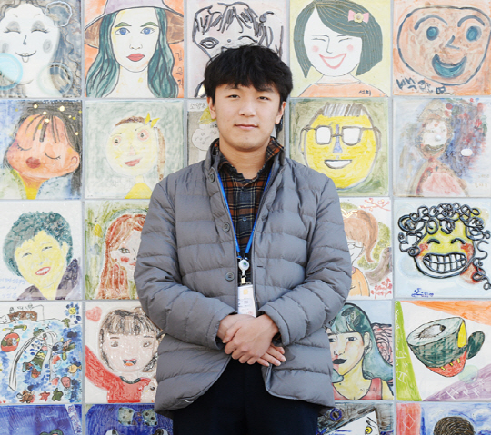 자폐성 장애에도 불구, 공개경쟁절차를 거쳐 공직에 들어와 뛰어난 업무능력을 발휘하고 있는 정길만 씨. 춘천시청 청사 외벽 앞에 전시 중인 다양한 표정을 지닌 춘천시민의 얼굴 앞에서 더 나은 행정서비스 제공에 매진하겠다는 포부를 밝히고 있다. 김동훈 기자 dhk@