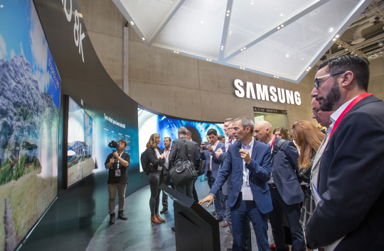 지난 8월 말 독일 베를린에서 열린 ‘유럽가전전시회(IFA) 2018’에서 관람객들이 처음 공개된 삼성전자의 ‘QLED 8K’ TV를 살펴보고 있다.