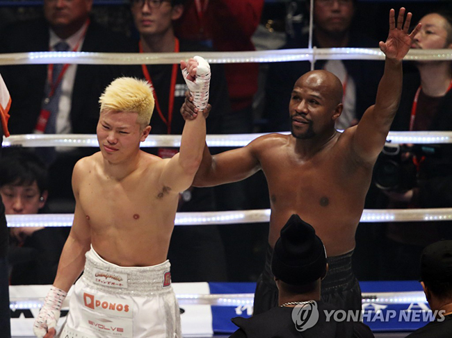 경기에서 승리한 메이웨더가 나스카와의 손을 들어주고 있다.[AP=연합뉴스]