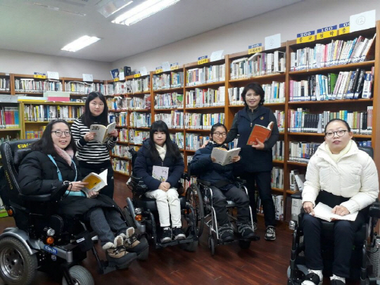 지체장애 제자들이 쓴 글을 모아 문집을 펴낸 박호숙(오른쪽 두 번째) 대구보건학교 교사가 학생들과 어울려 책을 읽으며 즐거운 시간을 보내고 있다. 박 교사는 “이들이 꿈을 펴는 데 조금이라도 도움이 되고 싶다”고 했다.  박호숙 교사 제공