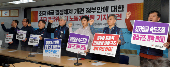 민주노총·한국노총 소속 최저임금위원회 노동자위원들이 9일 오전 서울 영등포구 여의동 한국노총 회의실에서 열린 긴급기자회견에서 정부의 최저임금 결정체계 개편안에 반대한다는 구호를 외치고 있다.