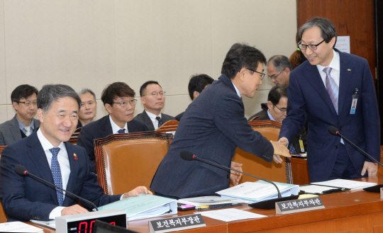 김성주(앞줄 오른쪽) 국민연금공단 이사장이 18일 오전 국회 보건복지위원회 전체회의에 출석해 권덕철(〃 가운데) 보건복지부 차관과 악수하고 있다. 앞줄 왼쪽은 박능후 보건복지부 장관.