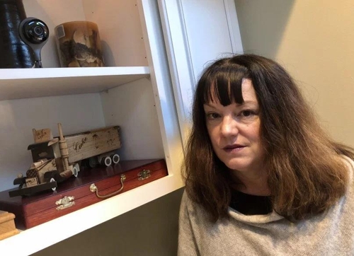 미국 캘리포니아주 오린다에 사는 로라 라이언스씨가 거실에 설치된 네스트 감시카메라(왼쪽 상단) 옆에 서서 사진을 찍고 있다. [출처=더 머큐리 뉴스 홈페이지]