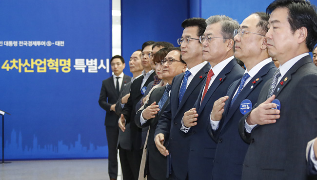 문재인 대통령이 24일 오전 대전 서구 대전시청에서 열린 ‘대전의 꿈, 4차 산업혁명 특별시’ 행사에서 홍남기(문 대통령 오른쪽) 부총리 겸 기획재정부 장관, 허태정(〃왼쪽) 대전시장 등 참석자들과 국기에 경례하고 있다. 연합뉴스