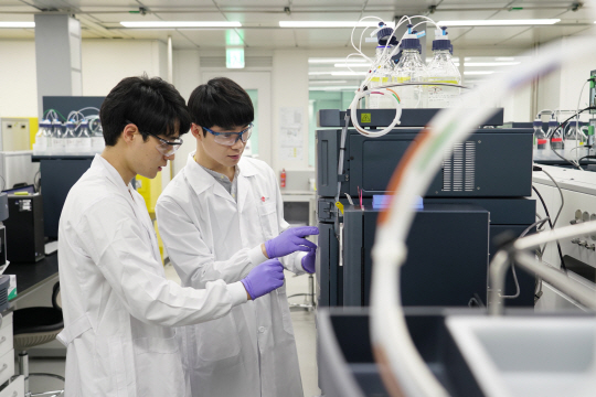 LG화학 연구원들이 마곡 LG사이언스파크 내 연구동에서 연구·개발(R&D) 작업을 하고 있다. 오른쪽 사진은 SK텔레콤이 지난해 선보인 인공지능 스피커 ‘홀로박스’ 모습. LG화학·SK텔레콤 제공
