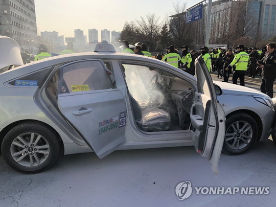 (서울=연합뉴스) 11일 오후 서울 여의도 국회 앞 도로에서 한 택시기사가 분신을 시도했다. 경찰 및 소방 관계자들이 현장을 정리하고 있다. 2019.2.11