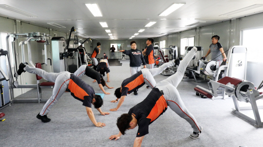 한화 선수들이 12일 일본 오키나와 고친다구장 웨이트트레이닝장에서 스트레칭으로 몸을 풀고 있다.  한화 제공