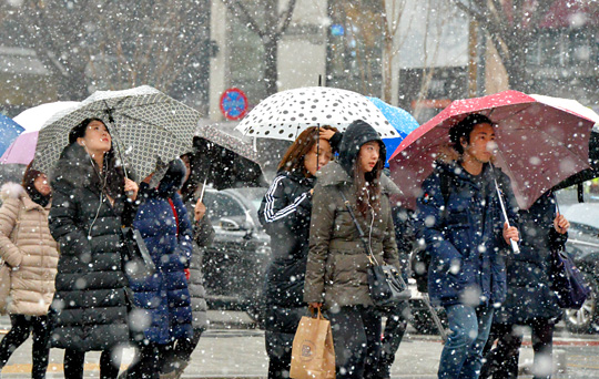 절기상 우수(雨水)인 19일 오전 서울과 경기 남부, 강원 영서 남부, 충북 북부, 경북 북부 등에 대설특보가 발령된 가운데, 서울 종로구 광화문광장 일대를 지나는 시민들이 눈을 피하기 위해 우산과 모자를 쓰고 출근하고 있다. 기상청은 이날 오전 10시 현재 서울에 2.4㎝의 눈이 내렸다고 발표했다.