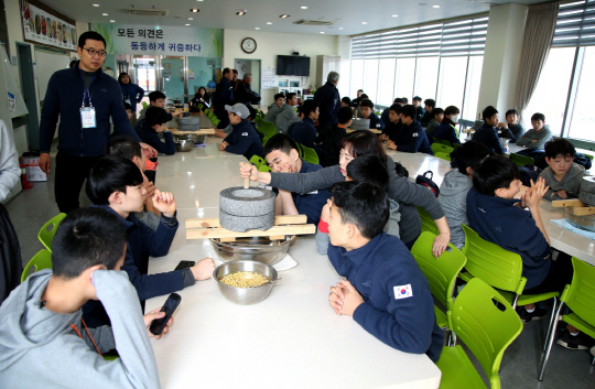 한국과 일본의 중학생 컬링, 아이스하키 선수들이 지난 25일 강원 강릉시에서 맷돌로 두부 만들기를 체험하고 있다. 대한체육회 제공