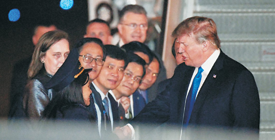 도널드 트럼프 미국 대통령이 26일 김정은 북한 국무위원장과의 2차 정상회담을 위해 베트남 하노이의 노이바이 국제공항에 도착한 뒤 영접 나온 미국 및 베트남 측 인사들과 악수를 하고 있다.   AP 연합뉴스