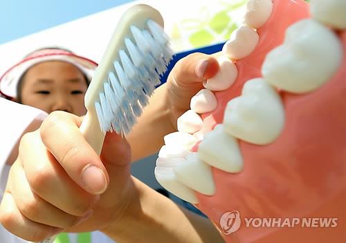 (서울=연합뉴스) 서울 송파구 한강시민공원 잠실트랙경기장에서 한 어린이가 바른 양치방법에 대해 배우고 있다. 2013.6.2