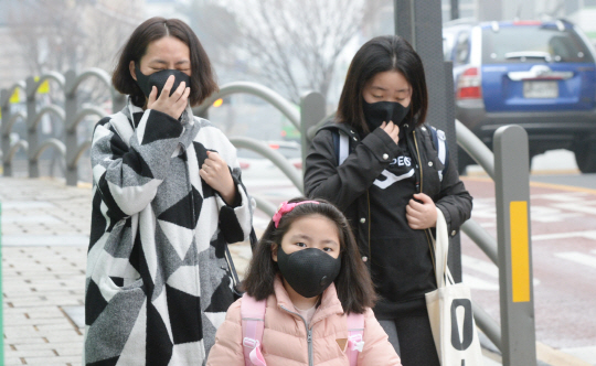 서울에 초미세먼지 경보가 발령된 5일 오전 서울 종로구 재동초등학교 정문에서 시민과 학생들이 마스크를 쓴 채 이동하고 있다.    김선규 기자 ufokim@