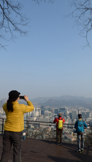 서울지역부터 미세먼지가 점차 걷히고 있는 가운데 7일 오전 중구 남산서울타워를 찾은 관광객들이 시내 전경을 카메라에 담고 있다.  김동훈 기자 dhk@
