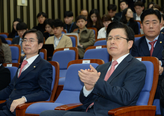황교안(오른쪽) 자유한국당 대표가 13일 오전 국회에서 열린 의원총회에서 박수를 치고 있다. 왼쪽은 조경태 최고위원.