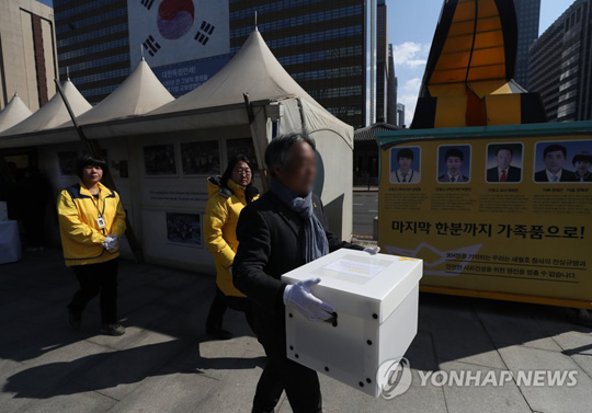 (서울=연합뉴스) 17일 서울 광화문광장 세월호 천막에서 열린 이안식에서 4·16 세월호 참사 유족들이 희생자 영정을 옮기고 있다. 세월호 천막은 2014년 7월 처음 설치된 후 약 4년 8개월 만에 유가족 측의 자진철거 의사에 따라 18일 모두 철거될 예정이다.