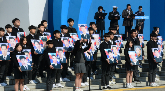 22일 오전 제2연평해전과 천안함 피격, 연평도 포격 도발로 희생된 ‘서해수호 55용사’를 추모하는 제4회 서해수호의 날 행사가 열린 국립대전현충원에서 대전한빛고 학생들이 전사자들의 사진을 들고 있다.