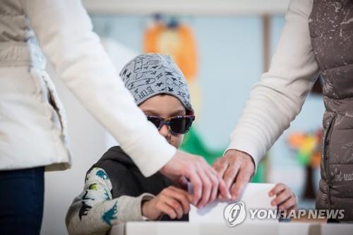 30일(현지시간) 대선 결선투표가 진행된 슬로바키아에서 한 어린이가 엄마와 함께 투표용지를 투표함에 넣고 있다. [epa=연합뉴스]
