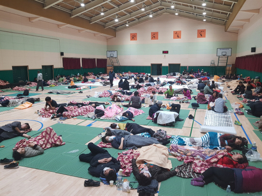 5일 오전 속초·고성 산불로 대피한 주민들이 임시 대피소가 마련된 강원 고성군 토성면 동광중학교 강당에 모여 있다.  연합뉴스