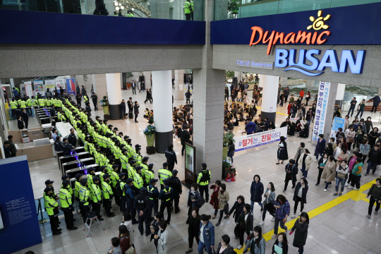 15일 경찰이 부산시청 로비에서 강제징용 노동자상 철거에 항의하며 연좌 농성을 벌이는 시민단체 회원들의 사무실 진입을 막는 가운데 민원인과 시청 공무원들이 농성장 옆을 지나가고 있다.   연합뉴스