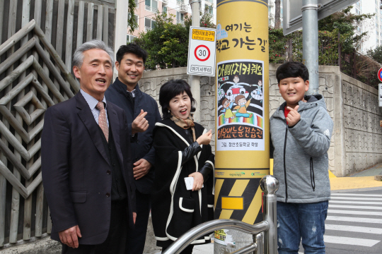 이홍력(왼쪽부터) 장산초교 교장, 강규태 한국전력 대리, 박정선 장산초교 교감, 강민석 군이 노란 전신주 앞에서 교통안전의 중요성을 강조하고 있다.  초록우산어린이재단 제공