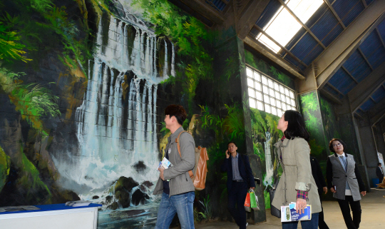 17일 ‘2019 도시재생 산업박람회’를 찾은 관람객들이 인천항 8부두 옛 곡물 창고를 재생한 박람회장의 벽화를 신기한 듯 바라보고 있다.