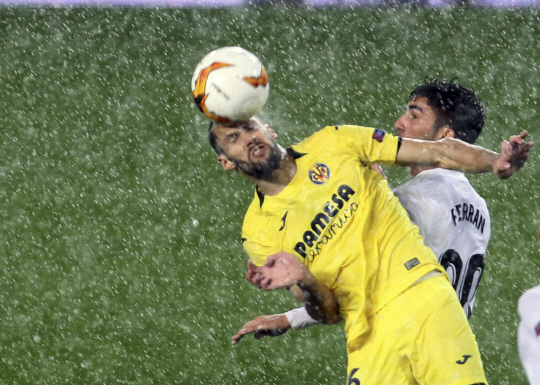 비야레알의 알폰소 페드라사(왼쪽)가 19일 오전(한국시간) 스페인 발렌시아의 메스타야 경기장에서 열린 발렌시아와의 UEFA 유로파리그 8강 2차전에서 폭우가 퍼붓는 가운데 헤딩하고 있다.  AP연합뉴스