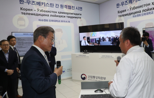 문재인 대통령이 18일 우즈베키스탄 타슈켄트에 있는 타슈켄트 인하대(IUT)를 방문, 한국·우즈베키스탄 간 원격 협진 시연을 지켜보며 관계자와 대화하고 있다.  연합뉴스