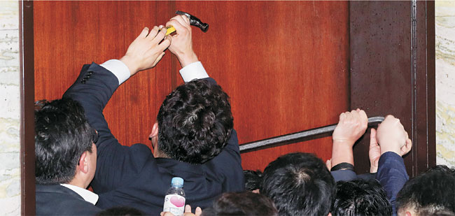 26일 오전 문희상 국회의장이 경호권을 발동한 가운데 국회 관계자들이 고위공직자범죄수사처(공수처) 설치법안 등의 패스트트랙 지정을 막기 위해 자유한국당 당직자들이 점거한 국회 본관 의안과 출입문을 장도리와 배척 등을 이용해 강제로 열고 있다. 뉴시스