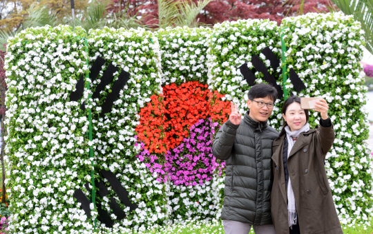 26일 오전 경기 고양시 일산 호수공원에서 개막된 고양국제꽃박람회장을 찾은 관람객들이 임시정부 수립 100주년을 기념해 조성한 정원에서 휴대전화로 기념사진을 찍고 있다.