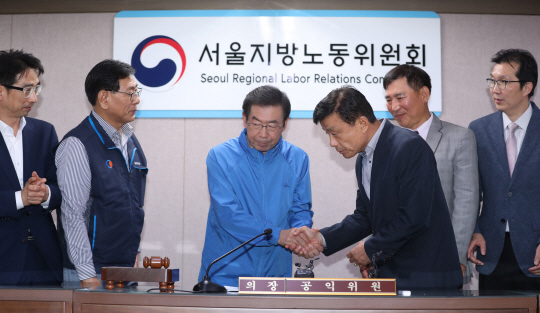 박원순(왼쪽 두 번째) 서울시장이 서울지역 버스노조 전면파업 1시간 30분을 앞둔 15일 오전 2시 30분쯤 피정권(〃 세 번째) 서울버스 운송사업조합 이사장, 서정수(왼쪽) 서울버스 노동조합 위원장 등과 임금단체 협약 협상을 타결짓고 악수하고 있다. 연합뉴스