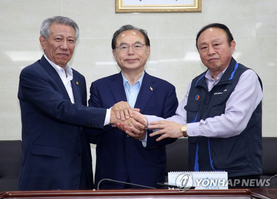 (부산=연합뉴스) 오거돈 부산시장과 부산 버스 노사가 15일 오전 첫차 운행시간을 지나서야 극적으로 협상을 타결한 뒤 손을 맞잡고 있다. 왼쪽부터 박찬일 부산버스운송조합 이사장, 오거돈 부산시장, 안홍준 부산버스노조 위원장.