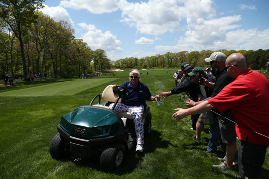 미국의 존 댈리가 17일 오전(한국시간) 미국 뉴욕주 파밍데일의 베스페이지 스테이트 파크 블랙 코스에서 열린 PGA챔피언십 1라운드 12번 홀에서 전동카트에 탄 채 팬들과 하이파이브를 하고 있다.  USA투데이 연합뉴스