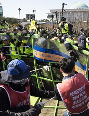 지난 4월 3일 서울 영등포구 여의동 국회 정문에서 민주노총 관계자들이 노동법 개악 저지 등을 촉구하며 경찰 펜스를 걷어내고 있다. 연합뉴스