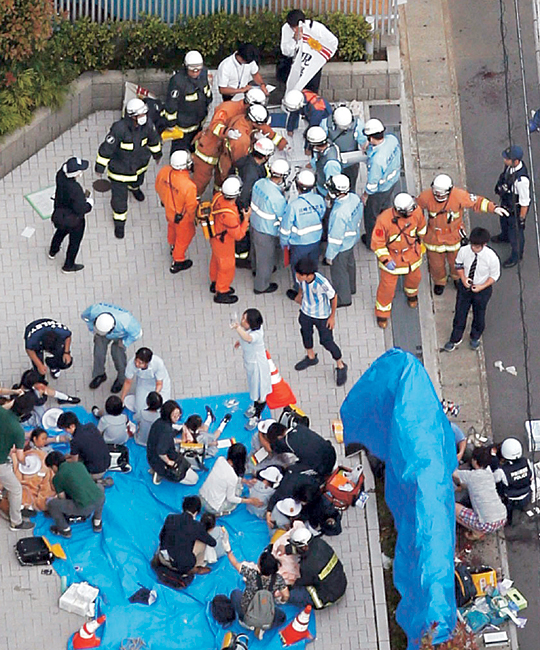 28일 오전 일본 도쿄 인근 가와사키시 노보리토공원에서 50대 남성이 버스정류장에 있던 행인들에게 무차별 흉기를 휘둘러 19명이 죽거나 다친 가운데 구조대가 출동해 응급조치를 하고 있다.  공동 AP 연합뉴스