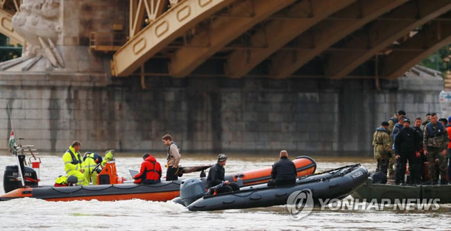(부다페스트=연합뉴스) 한국인 관광객들이 탑승한 유람선 ‘허블레아니’(헝가리어로 ‘인어’)가 침몰한 헝가리 부다페스트 다뉴브강 머르기트 다리 우측 세 번째 교각 부근에서 30일 오후(현지시간) 비가 잦아들며 경찰특공대 잠수요원(검정 수트)과 군 장병들이 수중 선체 및 실종자 수색을 위해 잠수 준비를 하고 있다.