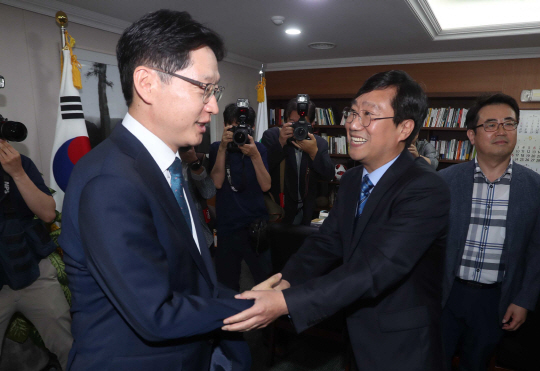 문재인 대통령의 핵심 측근으로 꼽히는 김경수(왼쪽) 경남지사와 양정철(가운데) 더불어민주당 민주연구원장이 10일 오전 경남 창원시 경남도청 지사 집무실에서 만나 밝은 표정으로 악수하고 있다.  연합뉴스