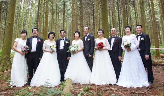 KT&G가 지난해 11월 제주도에서 진행한 ‘리마인드웨딩’ 행사에 선정된 직원 부모님들이 사려니 숲길에서 웨딩 기념사진을 찍고 있다.  KT&G 제공