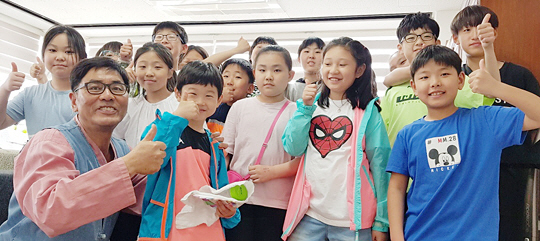 교내텃밭 체험학습 등 학생 참여 프로그램을 운영하고 있는 부산 사하구 중현초 채석도(64) 교장이 ‘방과후 학교’ 수업을 듣고 있는 3∼4학년 학생들과 함께 웃으면서 엄지손가락을 치켜들고 있다.    채석도 교장 제공