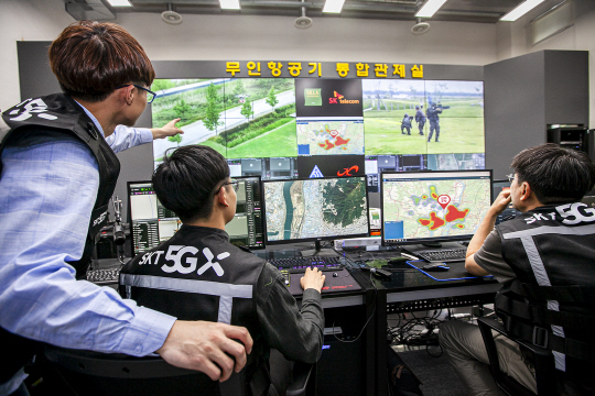 SK텔레콤, 신라대, 육군 53사단, 한빛드론은 ‘불법 드론 대응 체계’를 구축하고 지난 12일 부산 사상구 삼락생태공원에서 불법 드론 비행을 가정한 드론 대응 모의훈련을 진행했다. SK텔레콤 직원과 신라대 연구원들이 무인항공기 통합관제실에서 불법 드론 이륙 사실을 파악한 후 육군 53사단 등 유관기관에 전파하고 있다.  SK텔레콤 제공