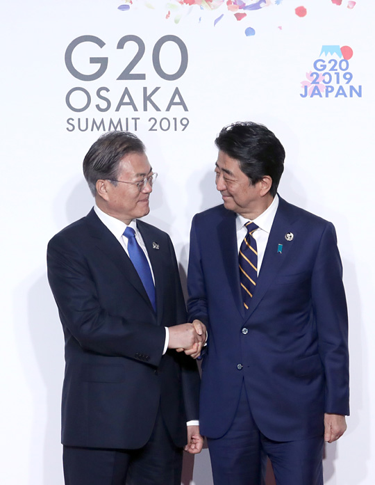 문재인 대통령이 28일 오전 일본 오사카의 인텍스 오사카에서 열린 주요 20개국(G20) 정상회의 공식 환영식에서 의장국인 일본의 아베 신조(오른쪽) 총리와 웃으며 악수하고 있다. 뉴시스