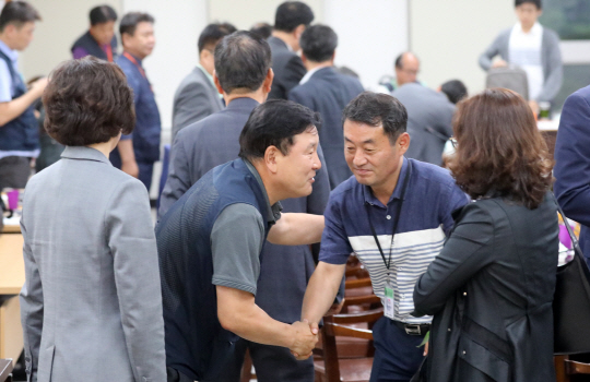 2020년 적용 최저임금 시급이 8590원으로 결정된 12일 정부세종청사 최저임금위원회 13차 전원회의에서 한국노총 사무총장인 이성경(오른쪽 두 번째) 근로자위원이 사용자위원들과 악수하고 있다.  뉴시스