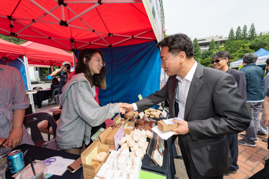 지난달 서울 광진구 화양동 건국대병원 옆 분수광장 일대에서 열린 ‘2019 광진구 사회적경제박람회’에서 청년 기업가와 인사하고 있는 김선갑 광진구청장.  광진구청 제공
