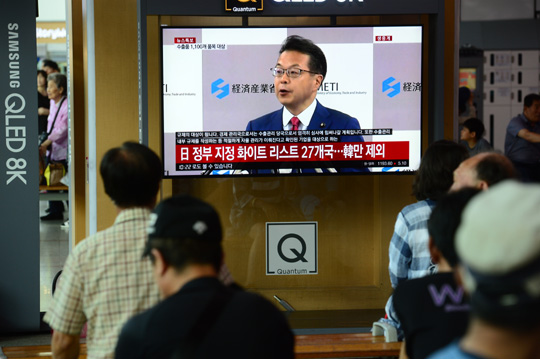 2일 오전 서울역에서 시민들이 일본 정부가 화이트리스트(수출 절차 간소화 국가) 한국 제외를 발표하는 TV 뉴스 속보를 시청하고 있다.
