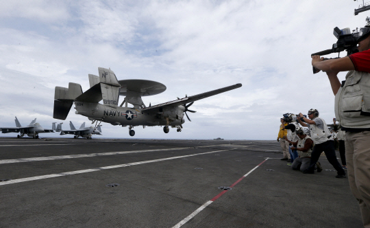 6일 미국의 E-2 호크아이 조기경보기가 남중국해 공해상에서 순찰을 마친 후 항공모함 로널드 레이건호에 착륙하고 있다.   AP연합뉴스
