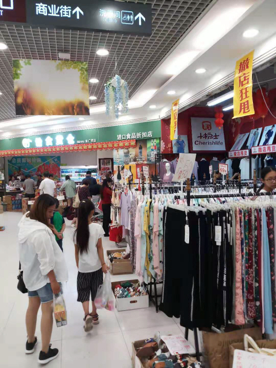 미·중 무역전쟁이 장기화하면서 중국의 각종 경제 지표들이 악화하고 있는 가운데 지난 18일 베이징 왕징 지역의 한 아울렛 1층 의류 매장에서 고객들이 ‘가게 정리 할인 세일’을 내세운 물건들을 둘러보고 있다.