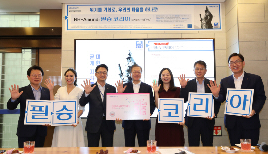 문재인 대통령이 26일 오전 서울 중구 NH농협은행 본점에서 ‘애국펀드’라고 불리는 ‘필승코리아 펀드’에 가입한 뒤 김광수(왼쪽) 농협금융지주회장, 이대훈(오른쪽) 농협은행장 등과 함께 손가락을 펼쳐 보이며 기념사진을 찍고 있다.  연합뉴스