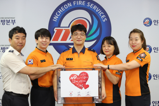인천소방본부 서영재(왼쪽 세 번째) 소방위와 동료 소방관들이 28일 ‘119원의 기적’ 모금함을 들고 있다.  인천소방본부 제공