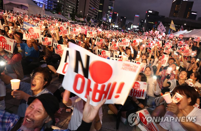 광복절인 8월 15일 오후 서울 광화문광장에서 열린 ‘아베 규탄 범국민촛불대회’에서 참가자들이 촛불을 밝히며 ‘노(NO) 아베’ 구호를 외치는 모습. [연합뉴스 자료사진]