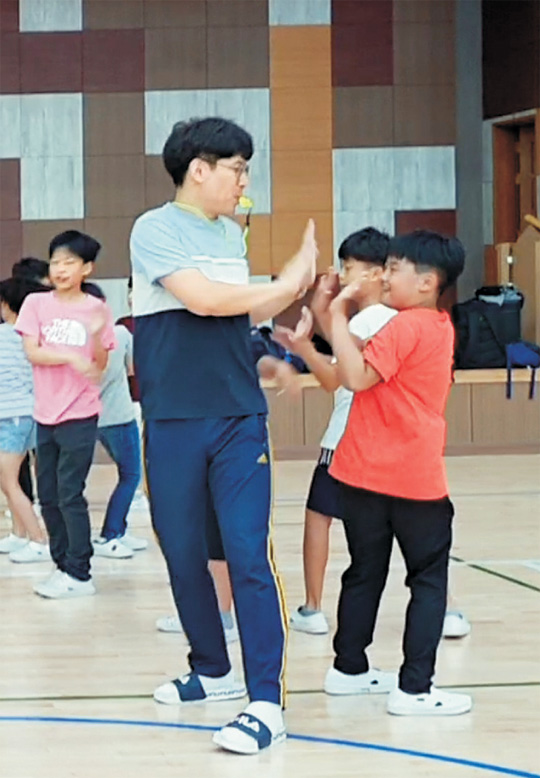 송성근(앞줄 왼쪽) 배곧누리초등학교 체육전담 교사가 지난 7월 학교 강당에서 학생들과 함께 놀이창작 동아리 활동을 진행하고 있다.   송성근 교사 제공